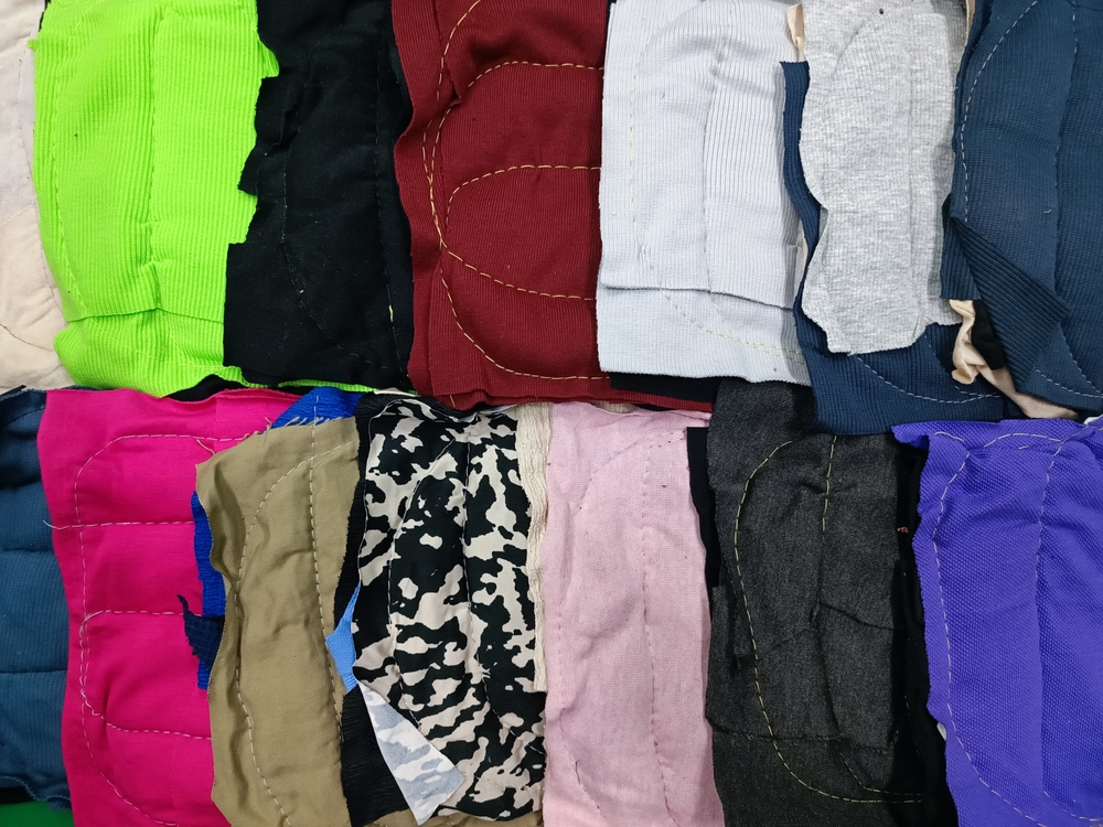 A color palette of clothing featuring warm tones like burgundy and mustard alongside neutral beige pieces.